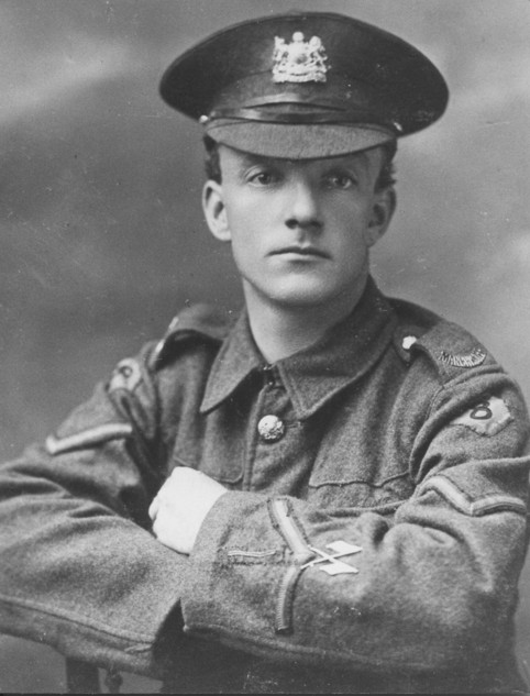 Posed photograph of a young World War I soldier.
			His uniform shows a lance-corporal's stripes and crossed flags of a signaller.